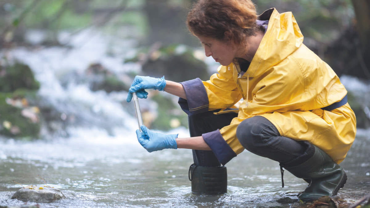 Female Biology Researcher Examining Water of a Stream. Environmental and agricultural research, Microbiology, Foundation, Sample technology, water testing